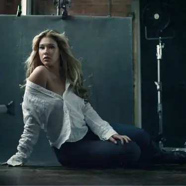 Woman in white cable-knit sweater seated against teal wall in editorial studio portrait with confident expression, photo by 312 Elements Headshot Photography, Chicago, IL portrait photographer