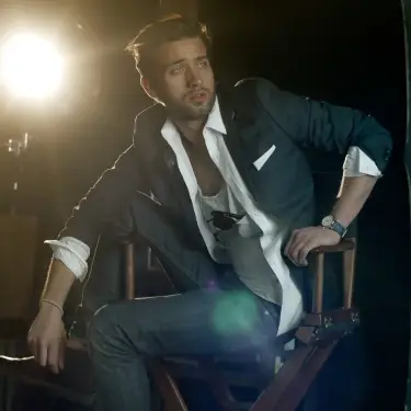 Actor in navy blazer seated confidently in director's chair with dramatic side-lighting creating cinematic professional headshot, captured by 312 Elements Headshot Photography, headshot photographer in Chicago, IL