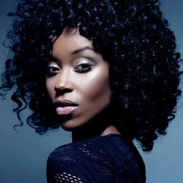 Cynovia Potts Chicago model professional headshot with voluminous curled hair against soft blue gradient background, image by Chicago, IL headshot photographer 312 Elements Headshot Photography