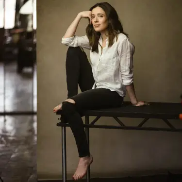 Marina Squerciati seated professional headshot with thoughtful expression in cream shirt against warm studio backdrop, photographed by Chicago, IL headshot photographer 312 Elements Headshot Photography