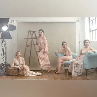 Vanity Fair style group portrait of four young women in period dresses on white studio set with ladder and upholstered furniture props, photo by 312 Elements Headshot Photography, Chicago, IL portrait photographer