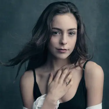 Jenna Albulet introspective headshot with long dark hair and graceful hand gesture against soft teal-green studio backdrop, image by Chicago, IL headshot photographer 312 Elements Headshot Photography