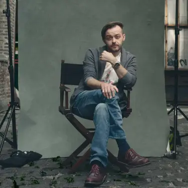Steven Kowalski professional portrait seated on director's chair in Chicago alley with studio lighting setup visible, image by Chicago, IL portrait photographer 312 Elements Headshot Photography