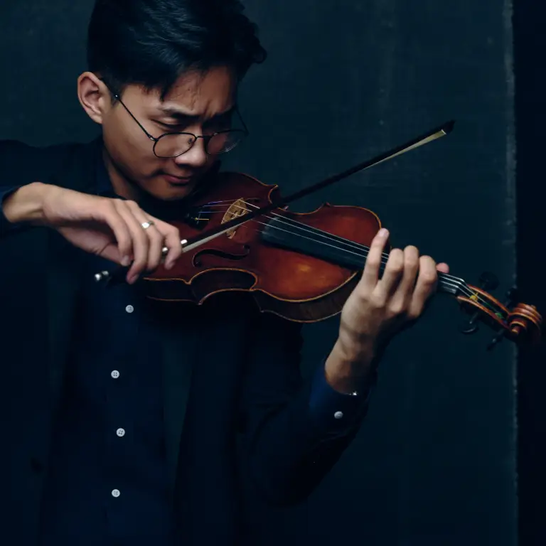 Tristan Zhu professional portrait playing violin glasses dark navy shirt deep teal background artistic lighting, image by Chicago, IL portrait photographer 312 Elements Headshot Photography