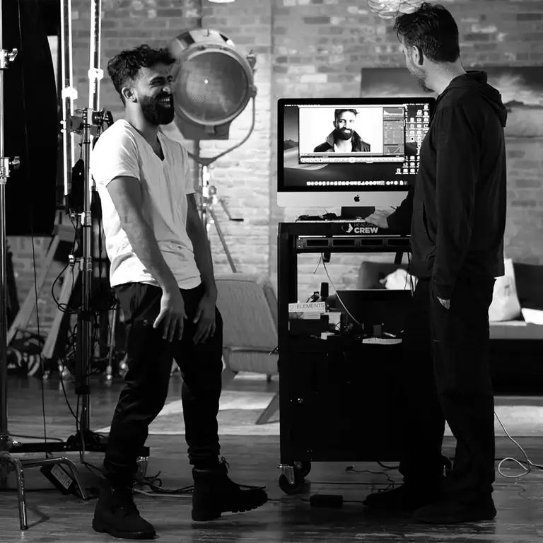 Client laughing with photographer Michael Schacht beside the tethered monitor in the 312 Elements West Loop headshot studio, Chicago