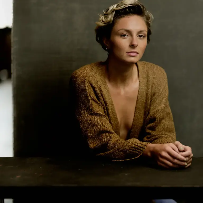 Emily DeBouver, Chicago women's relationship coach and dancer, in a sophisticated editorial branding portrait wearing a mustard cardigan with contemplative expression and moody studio lighting, photo by 312 Elements Headshot Photography, Chicago, IL portrait photographer