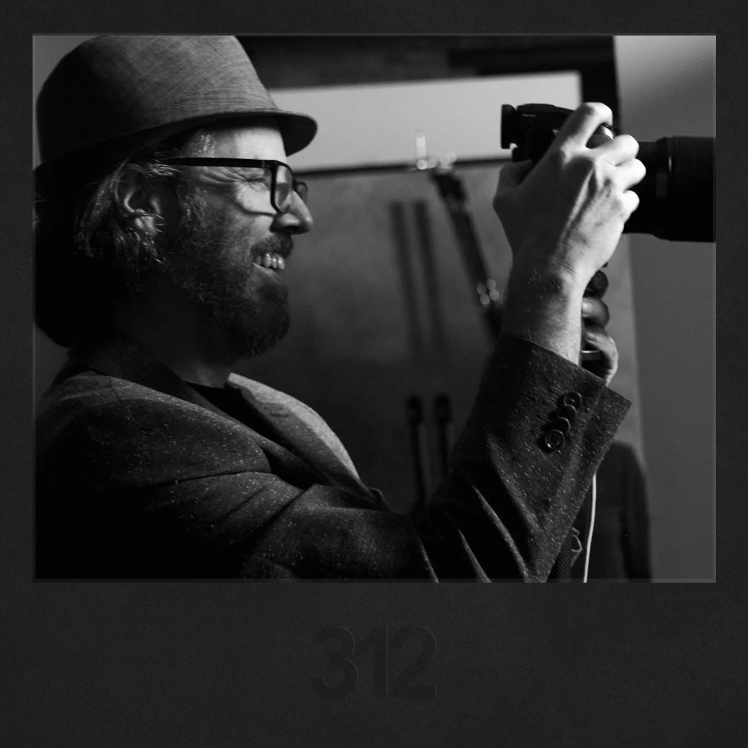 A focused photographer in a West Loop headshot studio looks at his camera's display, reflecting on his "outdoor headshots" session.